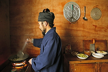 A monk cooking in the kitchen of the monastery Cui Yun Gong, Hua Shan, Shaanxi province, China, Asia