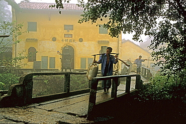 Porters carrying building material in front of Tianchi monastery at the village Jiuhuashan, Anhui province, China, Asia