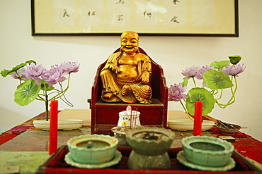 dining hall altar with Buddha statue and plastic lotus flowers, Jiuhua Shan Village, Monastery, Jiuhuashan, Mount Jiuhua, mountain of nine flowers, Jiuhua Shan, Anhui province, China, Asia