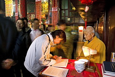 A monk and pilgrims at Longevity temple, Jiuhua Shan, Anhui province, China, Asia