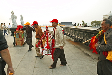 Pilgrims carrying Buddha statue and home altars for a blessing from Guanyin, Goddess of Mercy, Buddhist Island of Putuo Shan near Shanghai, Zhejiang Province, East China Sea, China