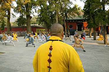 Shaolin Buddhist monk watching Kung Fu students, Shaolin Monastery known for Shaolin boxing, Taoist Buddhist, Song Shan, Henan province, China