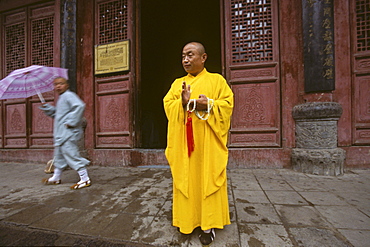 Shaolin monk leaving the temple after prayer, Shaolin Monastery, known for Shaolin boxing, Taoist Buddhist mountain, Song Shan, Henan province, China