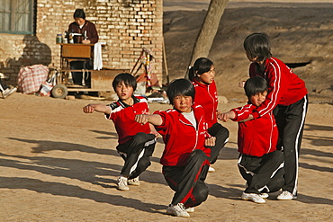 early morning Kung Fu training, school near Shaolin, a woman works on a sewing machine in the background, Song Shan, Henan province, China, Asia