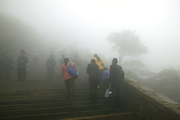 Pilgrims, tourists in rain capes near the entrance to Bixia Si temple in fog, Tai Shan, Shandong province, World Heritage, UNESCO, China