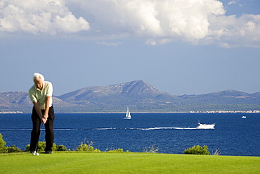 Senior man playing golf, Club de Golf Alcanada, Badia de Alcudia, Majorca, Spain