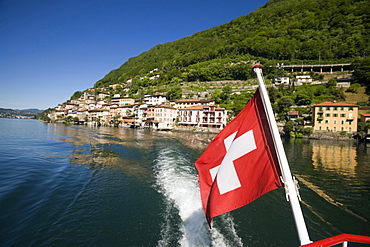 Motorboat on Lake Lugano leaving Gandria, a picturesque village at mountainside of mount Monte Bre, Ticino, Switzerland