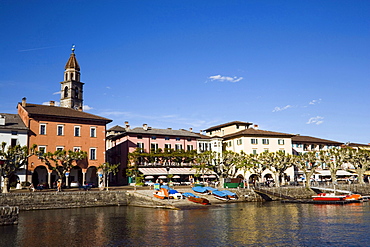 View over Lake Maggiore to harbour promenade with spire of church Santi Pietro Paolo in background, Ascona, Ticino, Switzerland