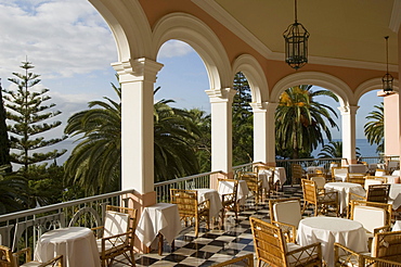 Chairs and tables on the sunlit terrace of Reids Hotel, Funchal, Madeira, Portugal