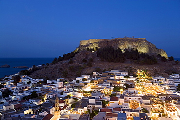 View over illuminated town at night to Acropolis, Lindos, Rhodes, Greece