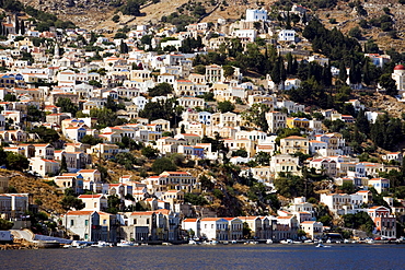 View from Aegean Sea to a sea of houses at mountainside, Symi, Simi Island, Greece