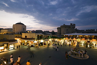 View over busy Platia Ippokratou with Thalassini Gate in background in the evening, Rhodes Town, Rhodes, Greece, (Since 1988 part of the UNESCO World Heritage Site)