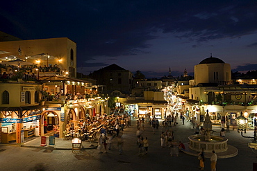 View over Platia Ippokratou with pavement cafes and shops in the evening, Rhodes Town, Rhodes, Greece, (Since 1988 part of the UNESCO World Heritage Site)