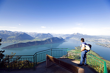 Man standing on vantage point Kaenzli, mount Rigi (1797 m, Queen of the Mountains) and looking over Lake Lucerne with Weggis, mount Buergenstock and mount Pilatus (2132 M), Rigi Kaltbad, Canton of Schwyz, Switzerland