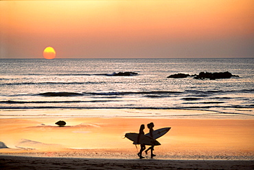 Surfer on Playa Coco at sunset, Costa Rica