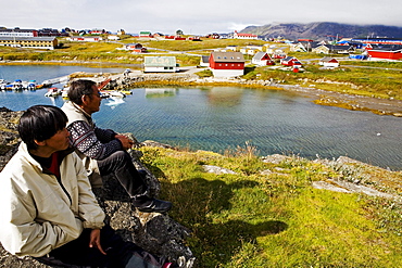 Two Inuit enjoy the view over Narsaq, South Greenland