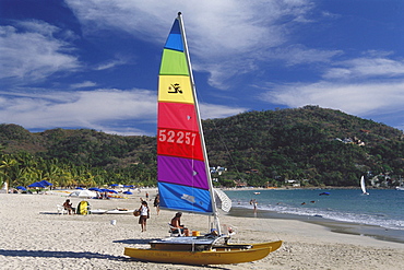 A boat, catamaran, on the beach at Playa la ropa, Zihuatanejo, Guerrero, Mexico, America