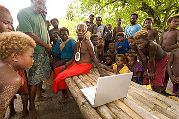 Traditional Tribe looking at Apple computer, New Ireland, Papua New Guinea, Oceania