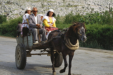 Locals in a horse carriage, landscape, North Albania