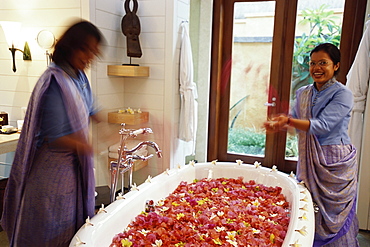 Women filling a bath with flower petals, Bathroom, Relaxation, Hotel Oberoi, Holiday, Mauritius, Africa