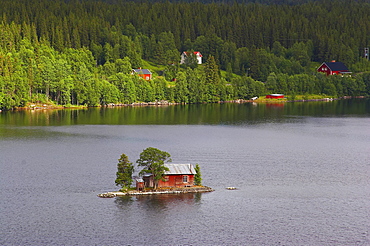 Small island with red wooden house in the lake Hetoegeln near Gaeddede, Jaemtland, northern Sweden