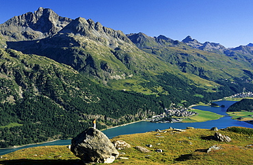 young woman on rock in alpine pasture high above lake Silvaplaner See and Champfer (ChampfÃˆr) See, Engadin, Grisons, Switzerland