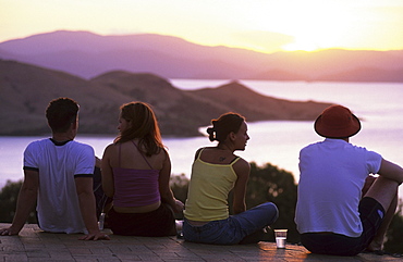 Four young people, couples enjoying the sunset from One Tree Hill on Hamilton Island, Whitsunday Islands, Great Barrier Reef, Australia