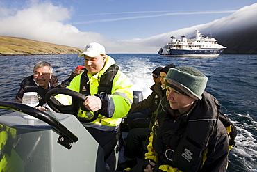 Tourists and seaman in an inflatable rubber boat, Hermaness, island of Unst, Shetland islands, Scotland, UK, Tourists