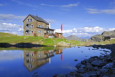 hut Flaggerschartenhuette with reflections in a lake, Marburg-Siegener Huette, Rifugio Forcella di Vallaga, Sarntal range, South Tyrol, Alta Badia, Italy