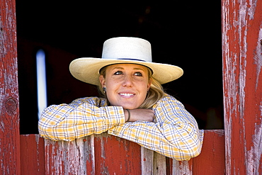 Cowgirl looking out of barn-window, wildwest, Oregon, USA