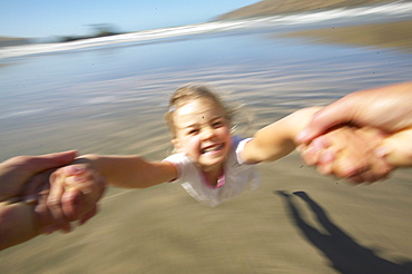 Girl (5 y.) turning around her father (flying merry go round), at Okains Bay, Bank`s Peninsula, east coast, South Island, New Zealand