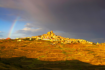 Landscape with rainbow and dramatic sky after a thunderstorm, small town on top of a mountain, UjueLands, Navarra, Spain