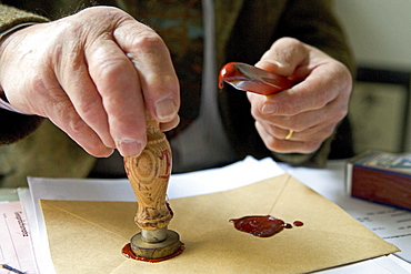 Notary fixes a seal on a document, last will and testament, inheritance seal, sealing wax