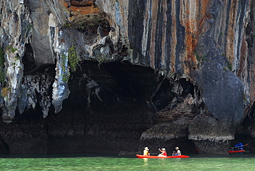 Canoe in front of limestone cliffs in the Bay of Phang Nga, Thailand