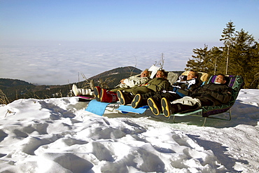 Family taking a sunbath in the wintersun, people, Hornisgrinde, Black Forest, Germany