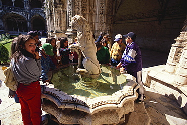 A group of children standing near a fountain, Cloister, Mosteiro dos Jeronimos, Hieronymites Monastery, Belem, Lisbon, Portugal