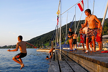 young men diving from landing stage, lake Attersee, Salzkammergut, Salzburg, Austria