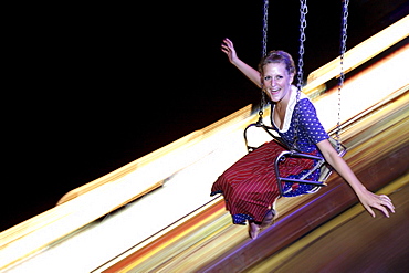 young woman sitting in a roundabout, Kaufbeuren, Bavaria, Germany