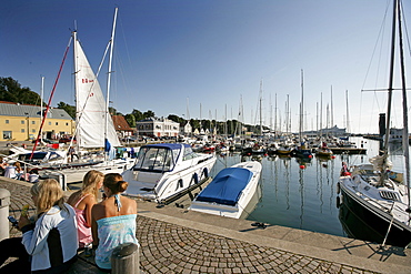 Three girls sitting by the harbour, Visby, Gotland, Sweden