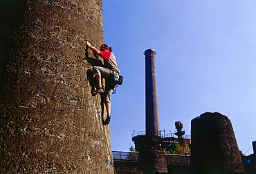 Climber climbing up a tower at Huette Meiderich, Public Park in Duisburg North, Duisburg, Ruhr Valley, North Rhine Westphalia, Germany