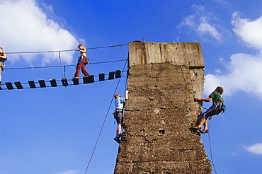 Climbers climbing up a tower at Huette Meiderich, Public Park in Duisburg North, Duisburg, Ruhr Valley, North Rhine Westphalia, Germany