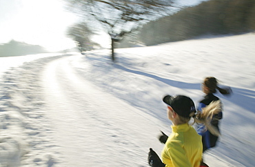 Two women jogging on snowy road, Styria, Austria