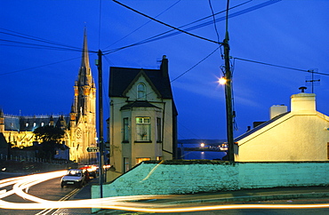 Calm street setting and the illuminated St. Colman's cathedral in the evening, Cobh, County Cork, Ireland, Europe