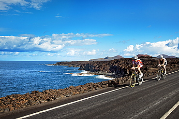 Cyclists at cliff coast, Los Hervideros, Lanzarote, Canary Islands, Spain, Europe