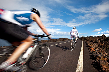 Cyclists at cliff coast, Los Hervideros, Lanzarote, Canary Islands, Spain, Europe