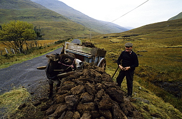 A farmer with donkey cart peat cutting, Doo Lough Pass, County Mayo, Ireland, Europe