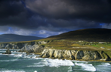 Surge in front of the steep coast under dark clouds, Achill Island, County Mayo, Ireland, Europe