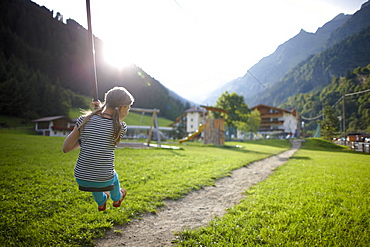 Girl playing on the zip line, outdoor area of Hotel Feuerstein, Pflersch, Gossensass, South Tyrol, Italy