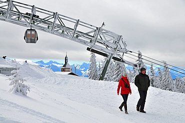 Man and woman in front of the cableway, on the Wallberg, winter in Bavaria, Mangfall Range, Bavarian Pre-Alps, Upper Bavaria, Bavaria, Germany