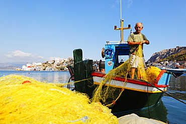 Fisherman on his boat in the port of Kastelorizo Megiste, Dodecanese Islands, Greece, Europe